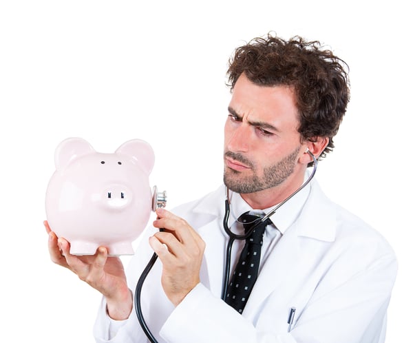 doctor using medical stethophone on a piggy saving pot