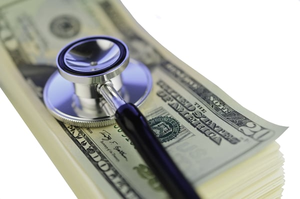 a medical stethophone on a stack of money