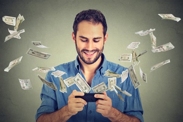 a men looking at the phone and money flying out from the phone